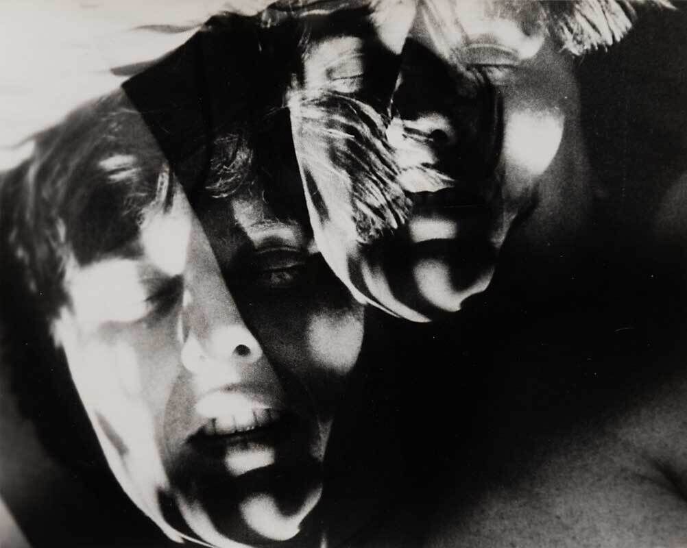 Two overlays of a resting person's face in black and white, casting shadows on one another.