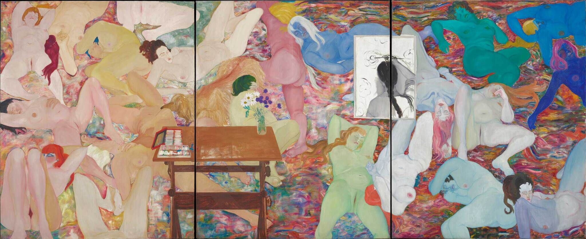 Several nude figures in various colors lie on a colorful surface, with a table, flowers, and art supplies in the center.