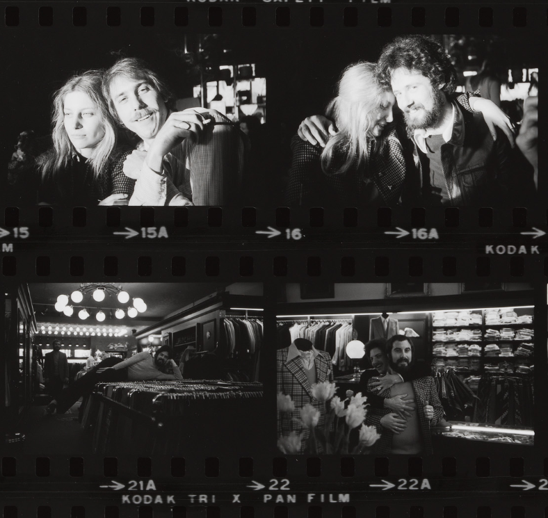 Four black and white photos show two people together, smiling and hugging, in a clothing store with racks of suits.