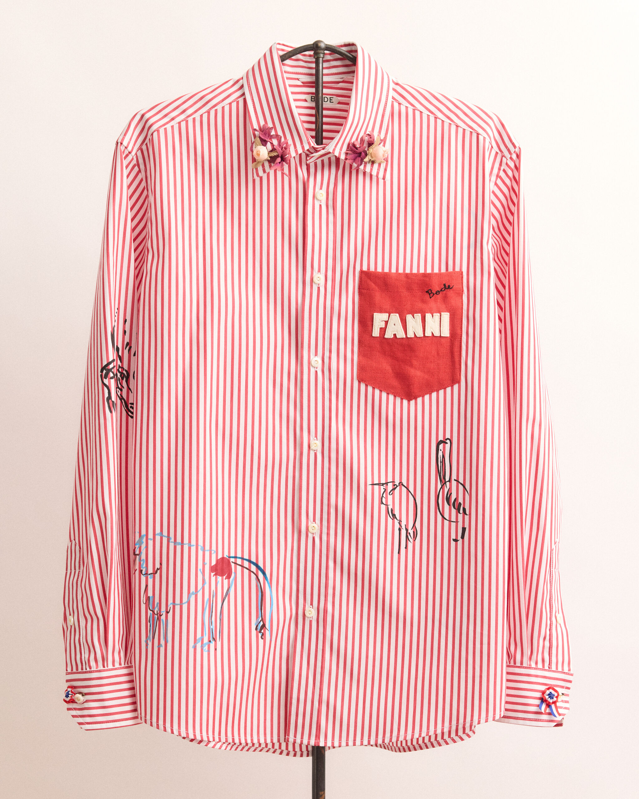 Red and white striped button-down shirt with a red pocket embroidered "FANNI" and small bird sketches.