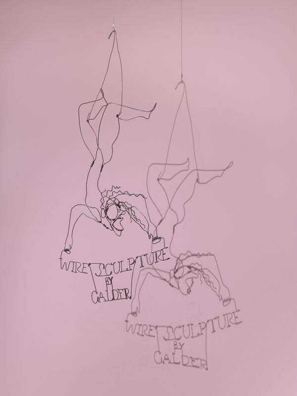 Delicate hanging wire sculpture of two acrobats with "Wire Sculpture by Calder" text.