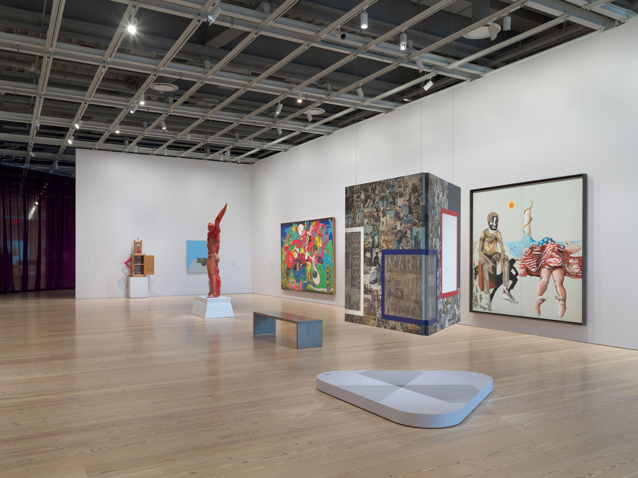 Red twisted human-like sculpture stands on a white plinth in a gallery.