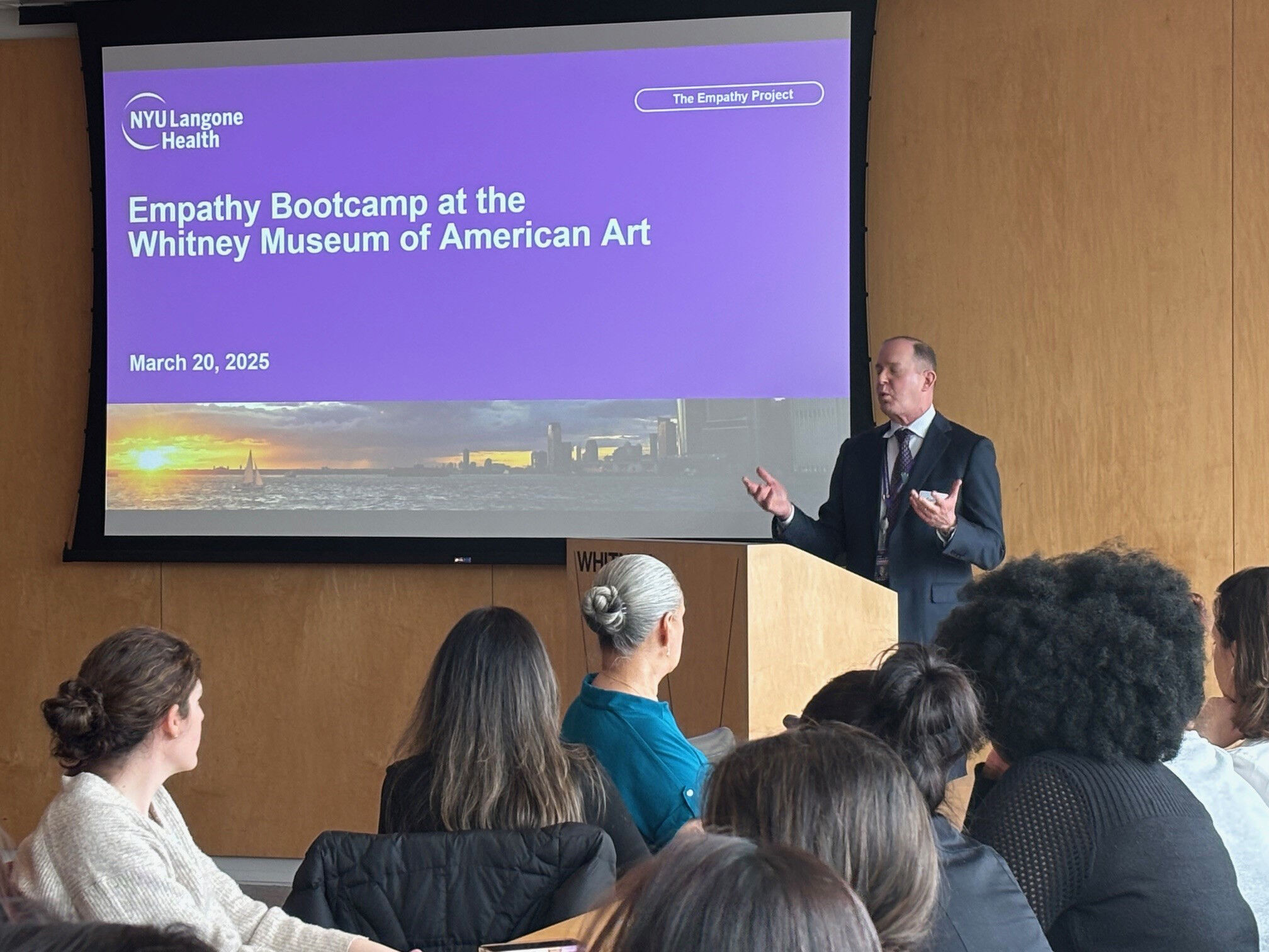 A presenter speaks to an audience in front of a slide titled Empathy Bootcamp.