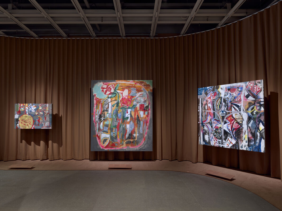 Three large colorful abstract paintings displayed on a brown-curtained gallery wall.