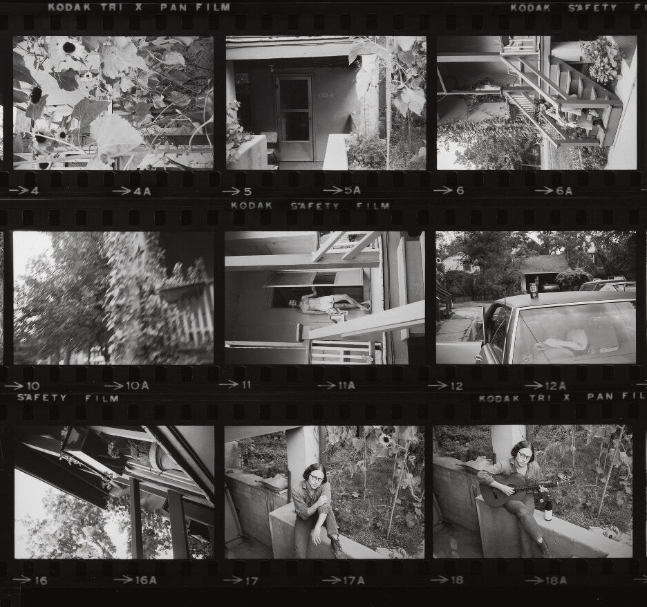 A black-and-white contact sheet of film negatives showing a series of photographs of a house, plants, and a person outdoors. The frames include close-up images of leaves, a car, and a person holding a guitar. 