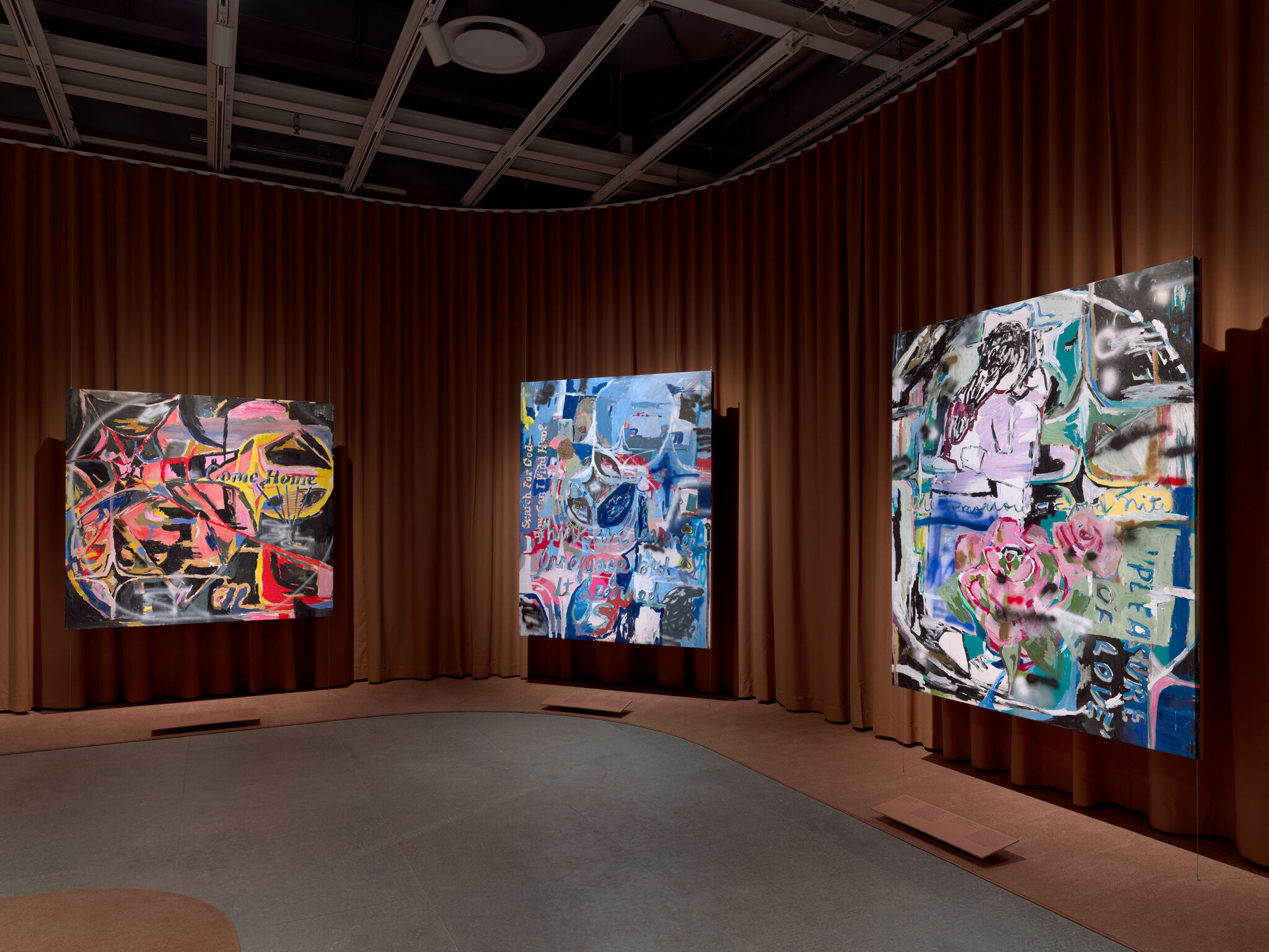 Three large colorful abstract paintings hung on a curved brown curtain wall.