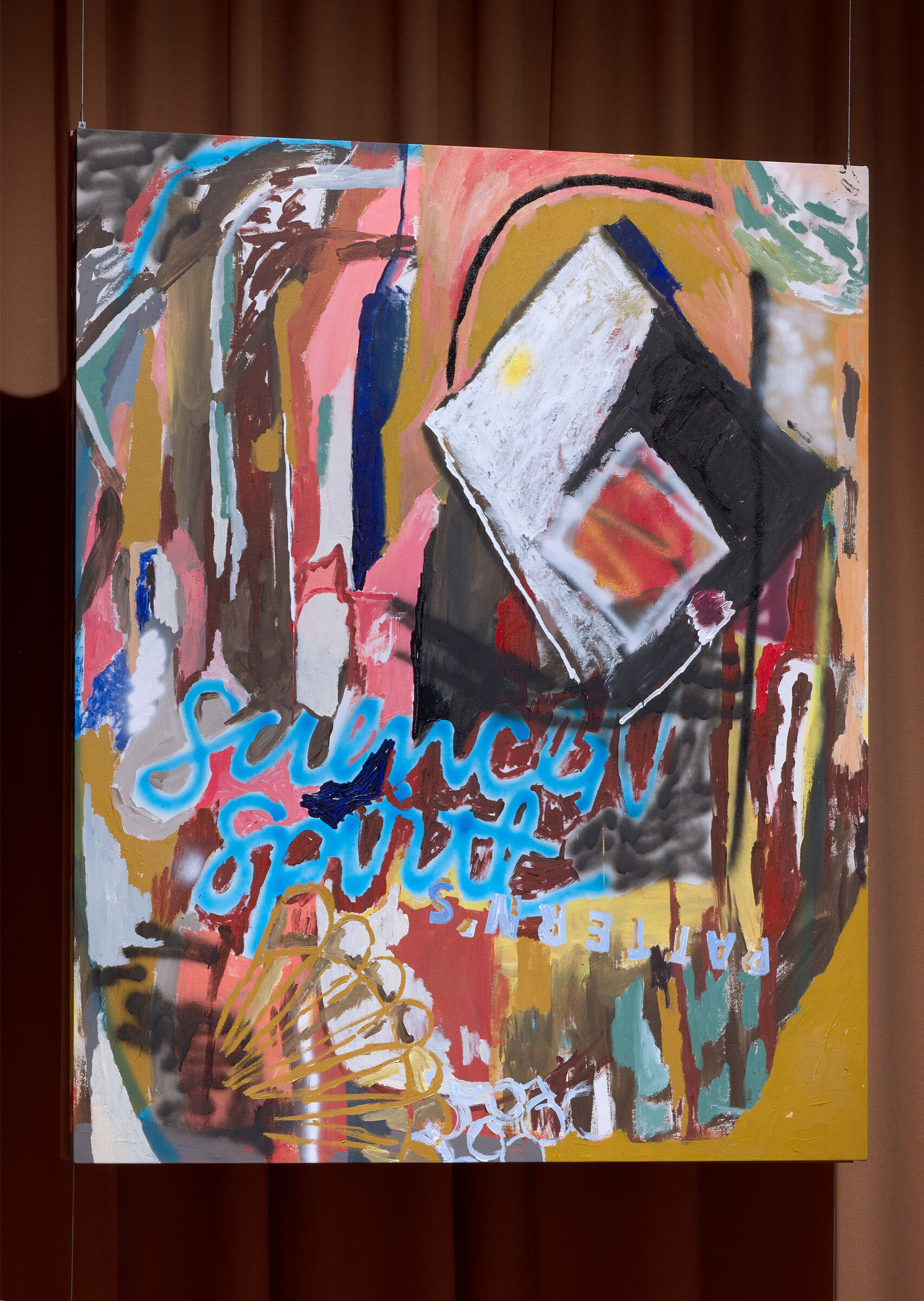 Colorful abstract painting with bold brushstrokes and layered shapes hanging against brown curtains.