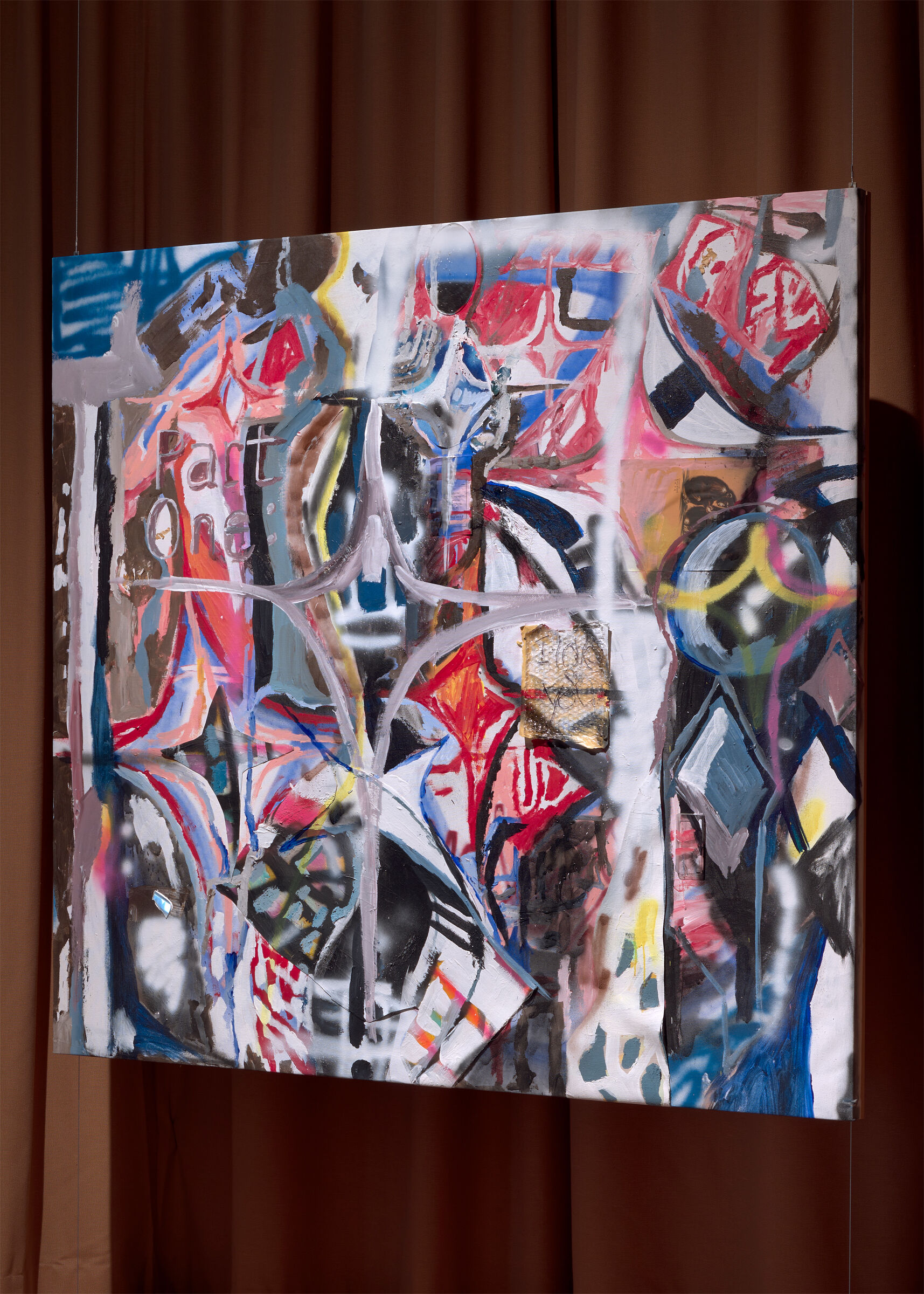 Colorful abstract painting with geometric shapes and brushstrokes hanging against a brown curtain.