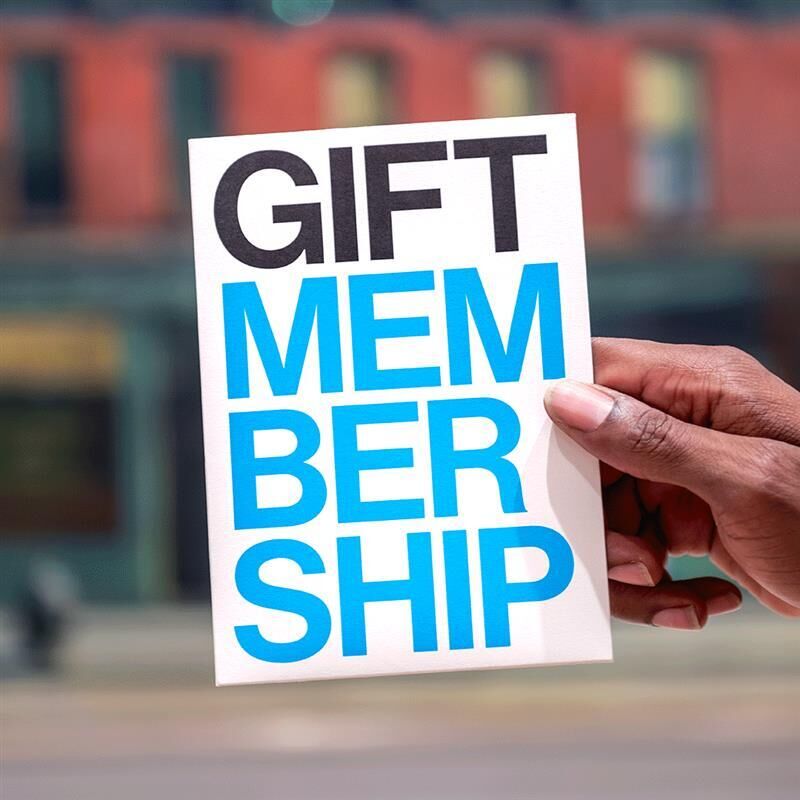 A hand holds a card that reads "GIFT MEMBERSHIP" in bold black and blue letters.