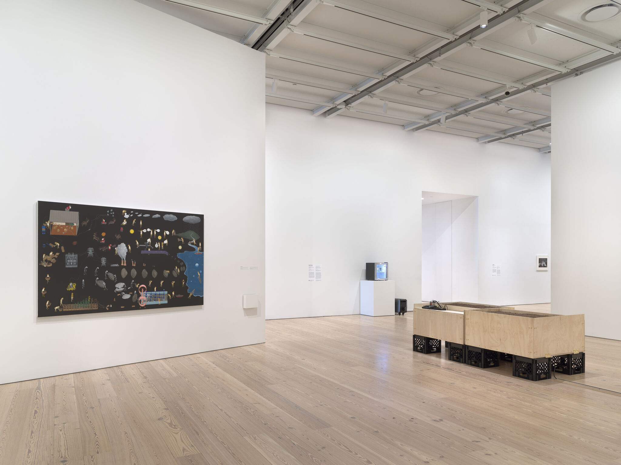 Gallery room with a large dark painting on the left wall and a wooden crate-supported bench installation on the right.