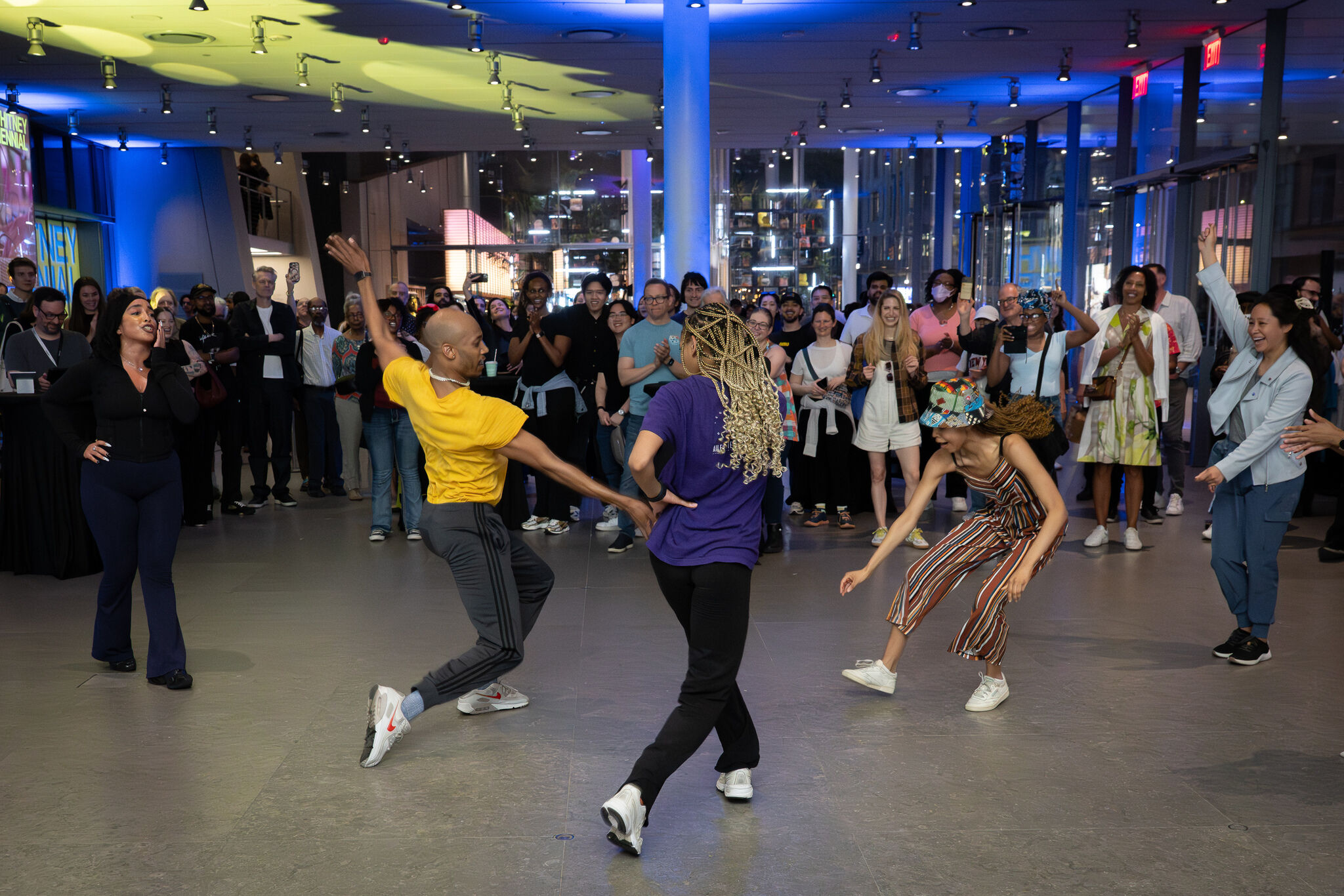 Dancers performing an energetic routine in the center while a crowd watches and cheers.