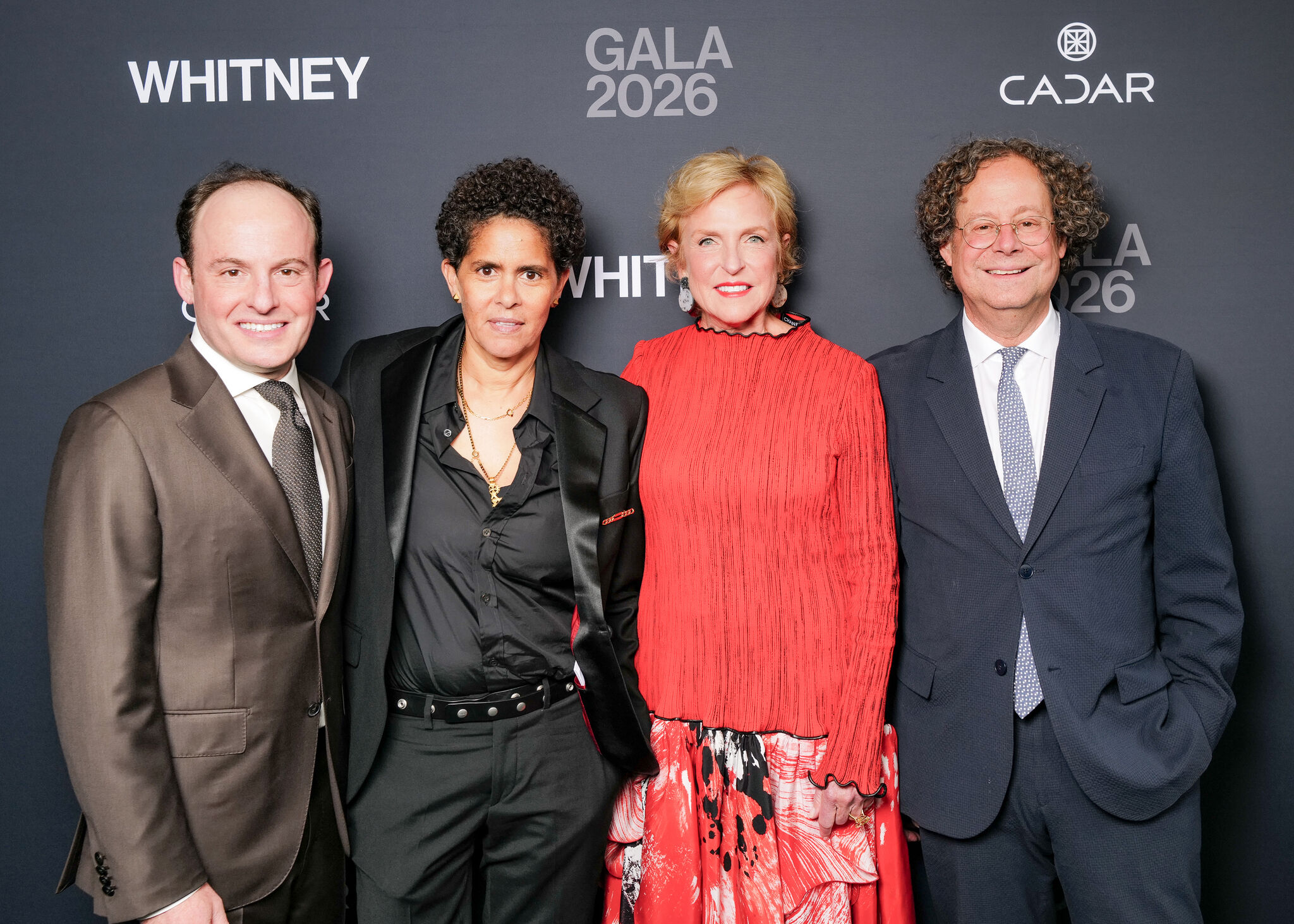 Four people stand together smiling at the Whitney Gala 2026 backdrop.