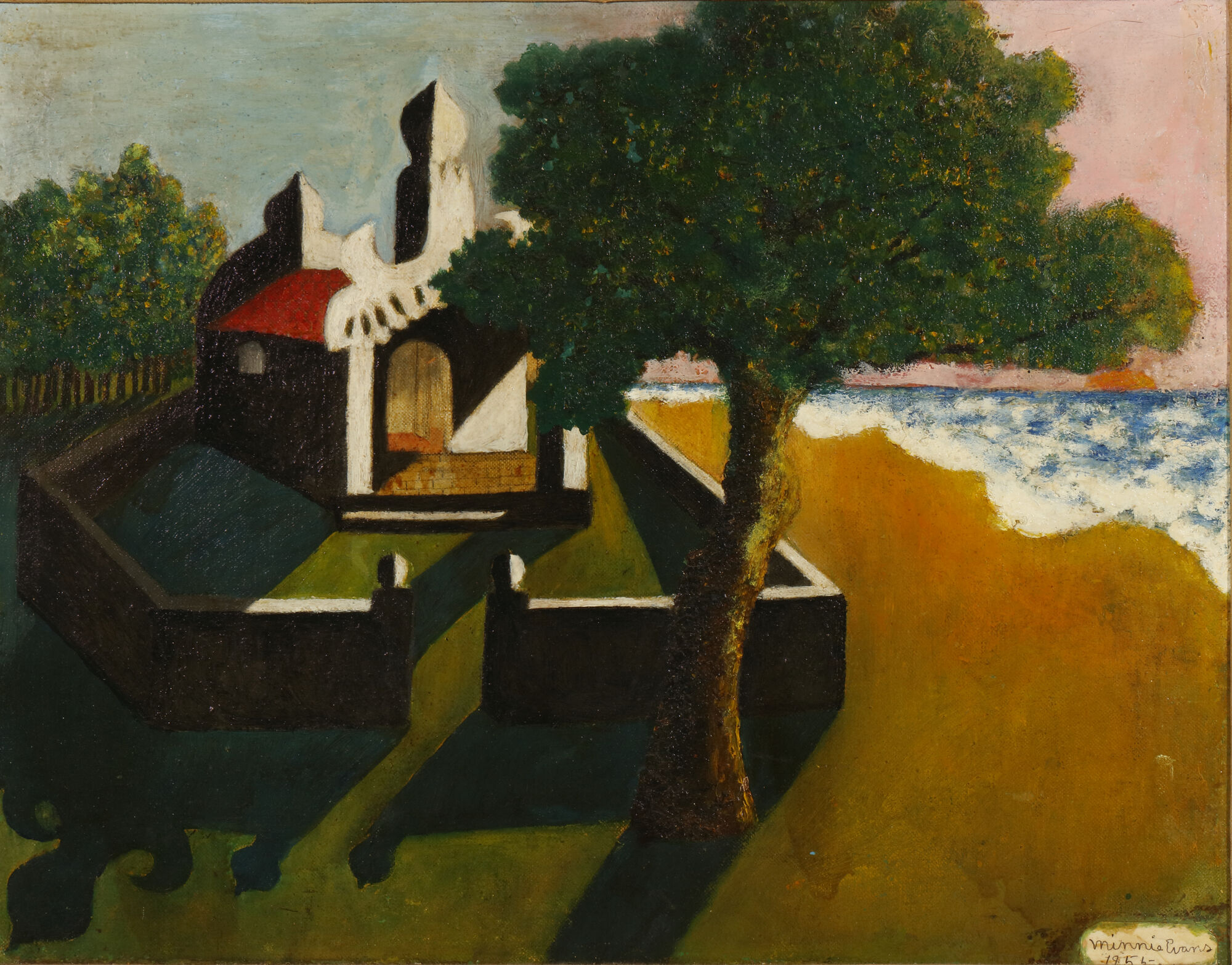 A small white coastal house beside a large tree casting long shadows toward a sandy beach.