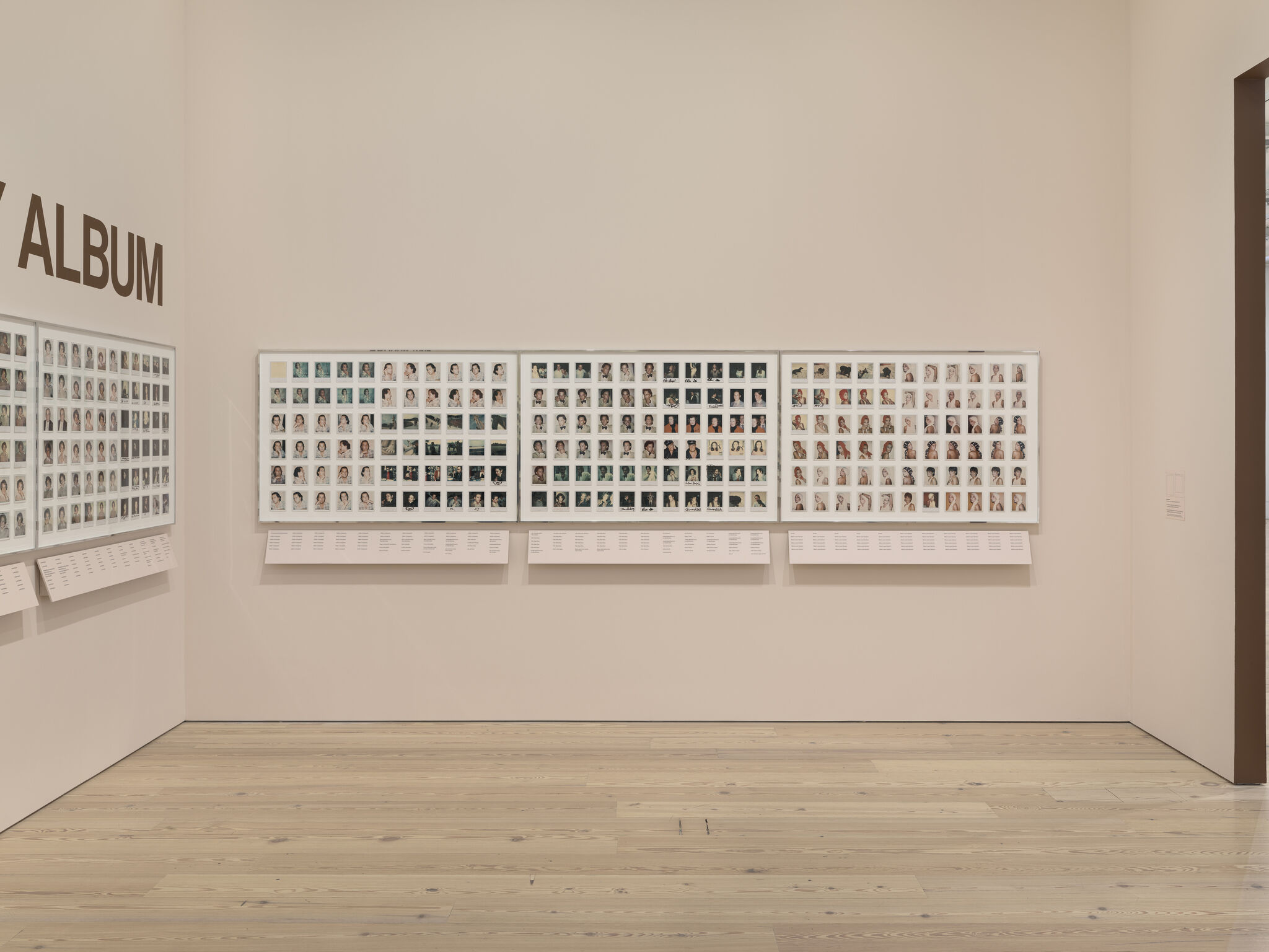 A gallery wall displays framed contact-sheet photos under a large sign reading ALBUM.
