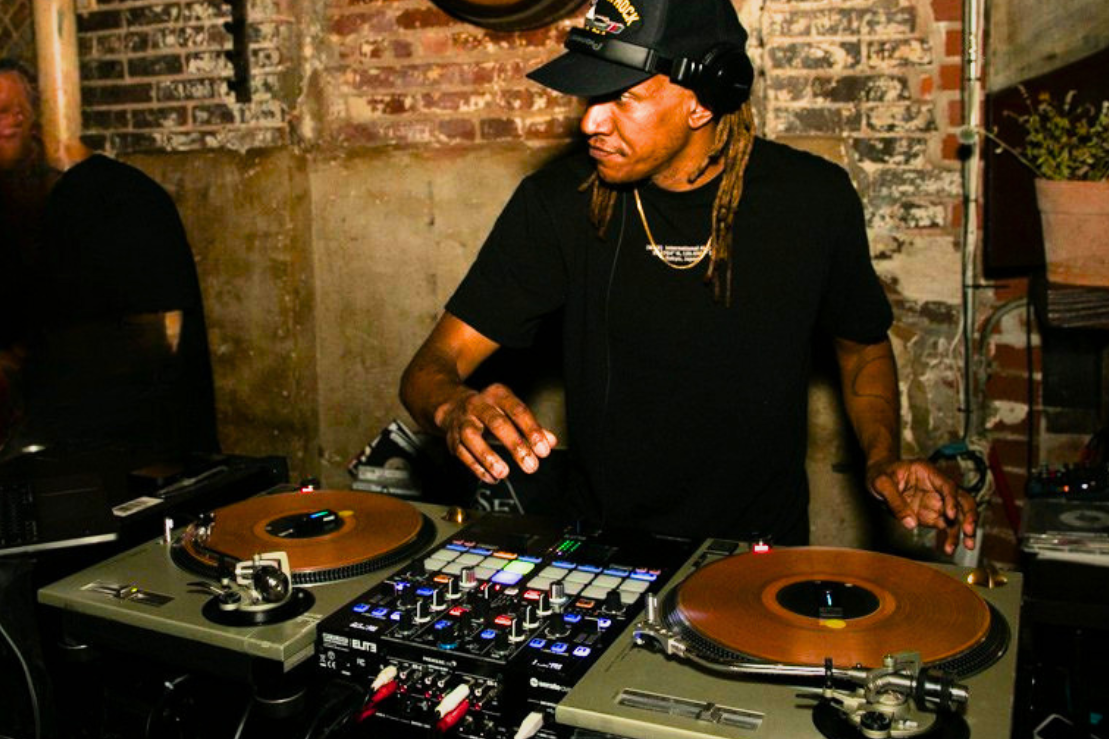 DJ John Swan in a black shirt behind the decks.