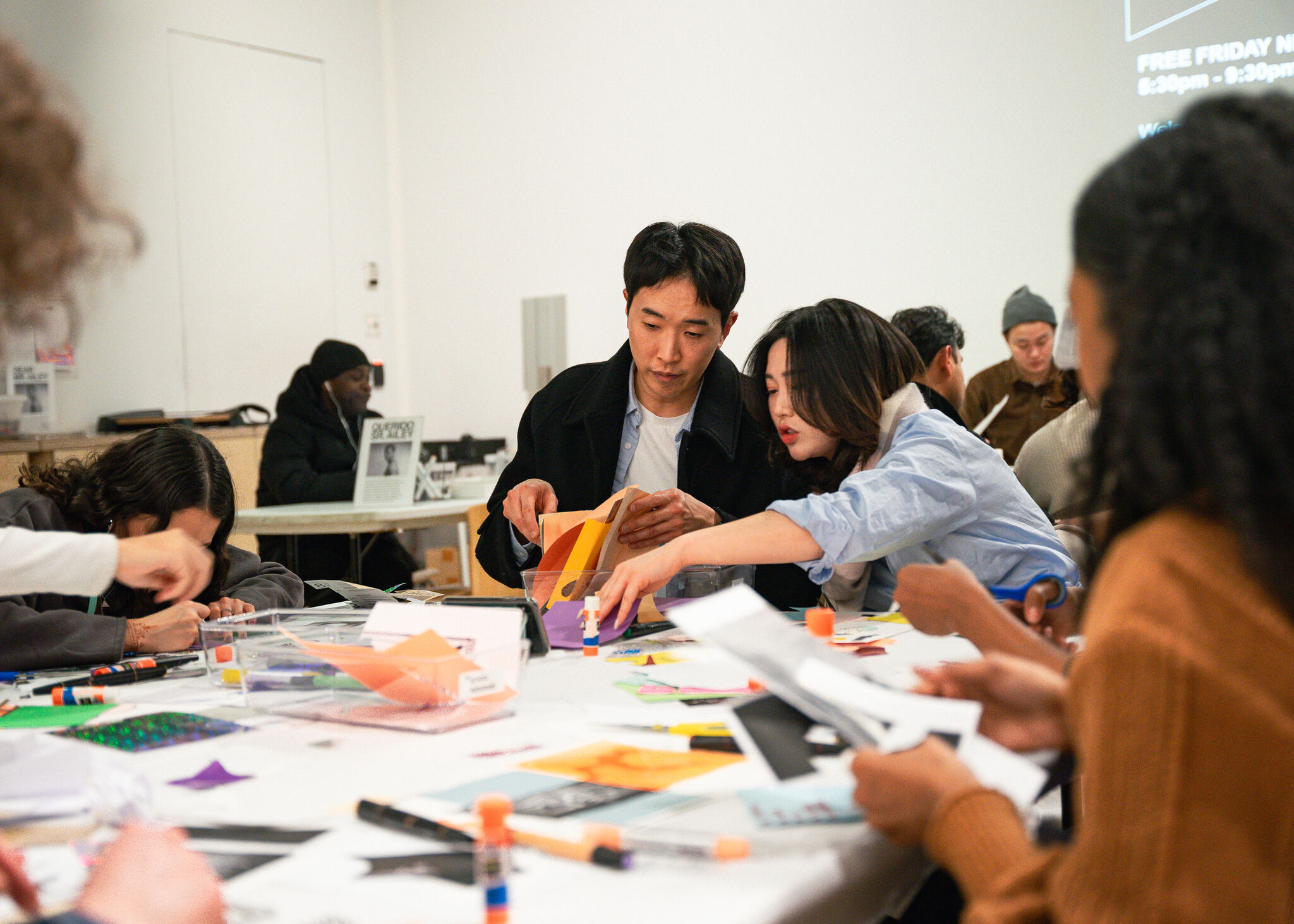 A group of people making art with paper and glue.