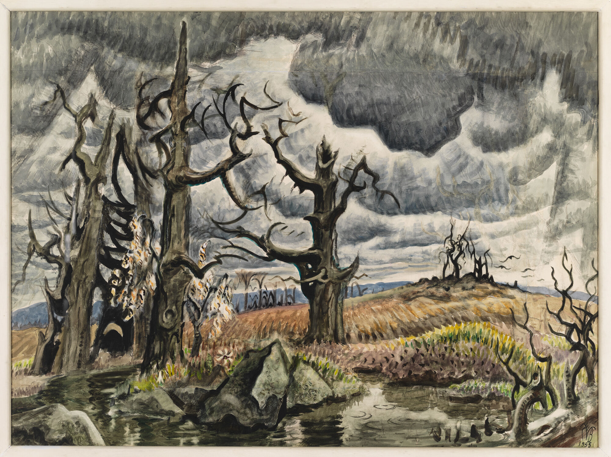 Twisted leafless trees stand by a swollen stream under dark storm clouds over harvested fields.