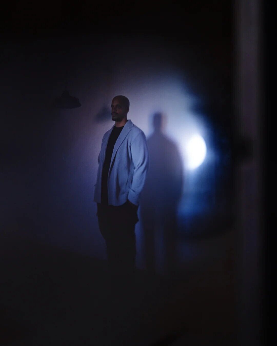 Chris Ryan Williams in blue atmospheric lighting